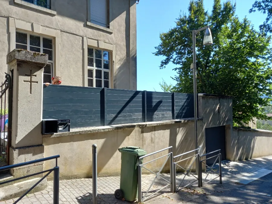 Clôture anthracite installée sur un muret devant une maison